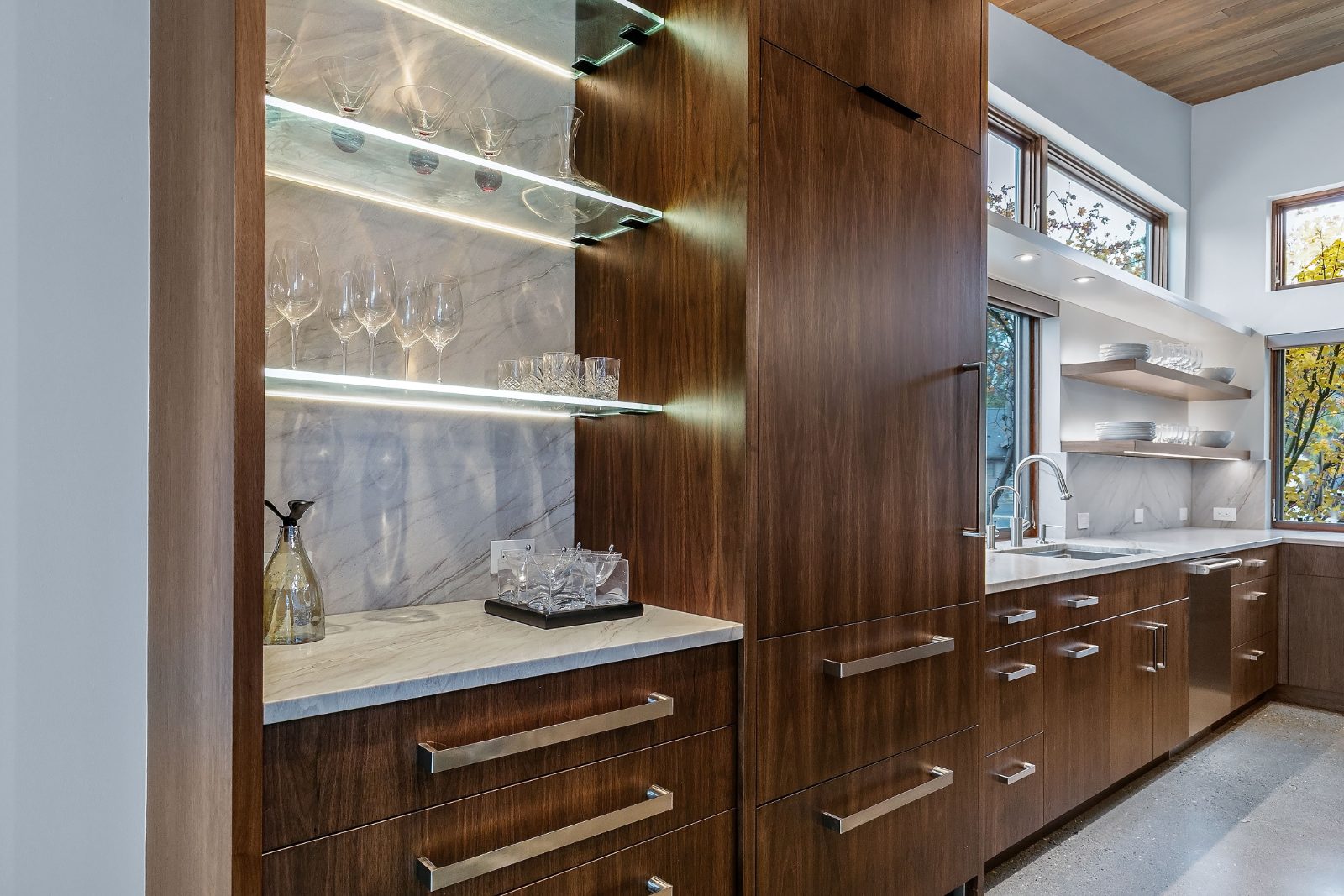 Custom walnut bar cabinetry with lighted glass shelving, Bend Oregon