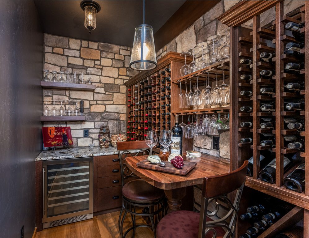 Traditional stone-walled wine cellar with custom wood bottle racking and tasting table, Central Oregon